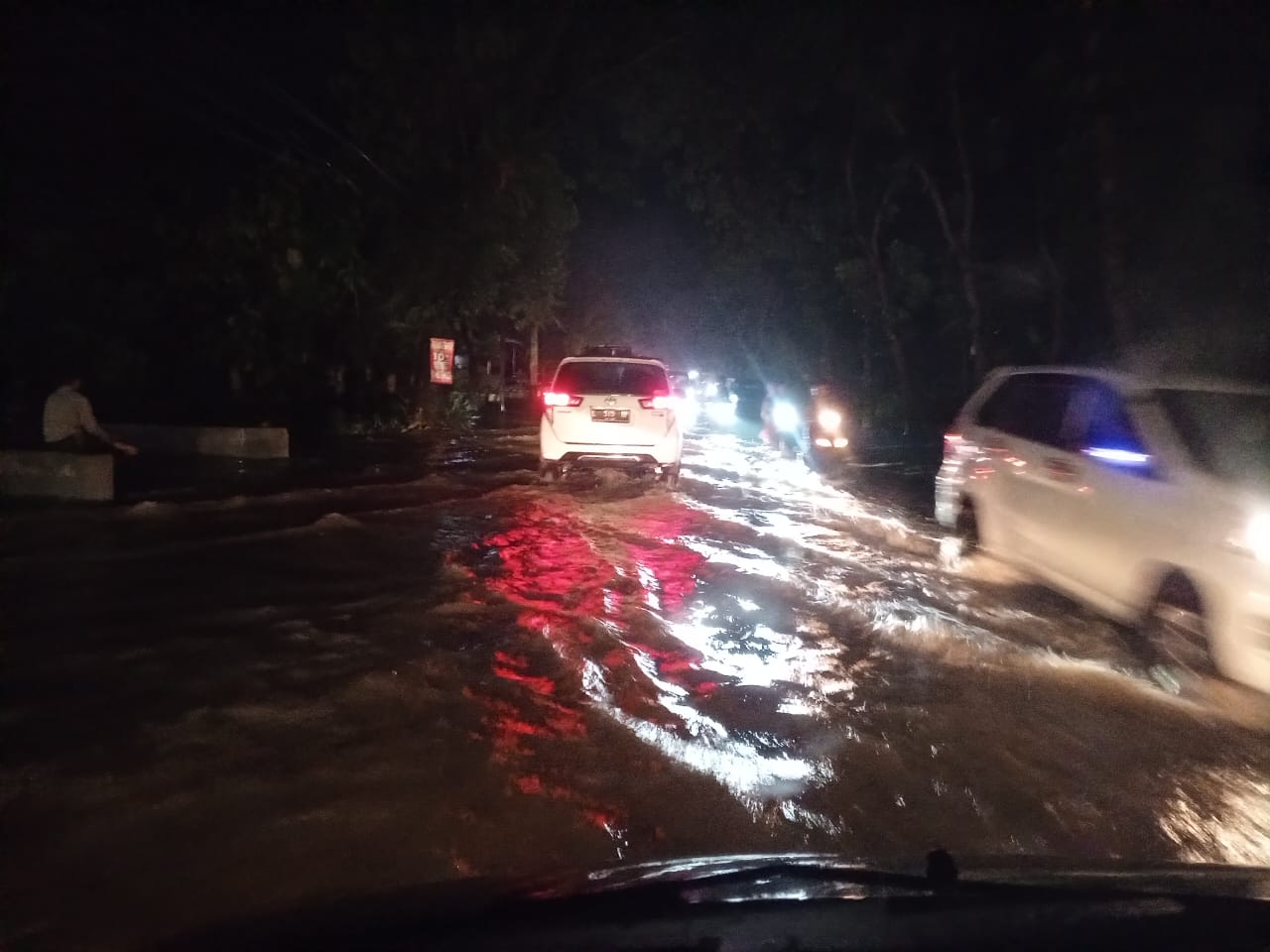 Arsu lalu lintas menuju ke Kabupaten Jember menerobos banjir yang merendam jalan nasional Surabaya-Jember di Desa Petung, Kecamatan Bangsalsari Jember, Jumat (8/3/2024). Foto:SF